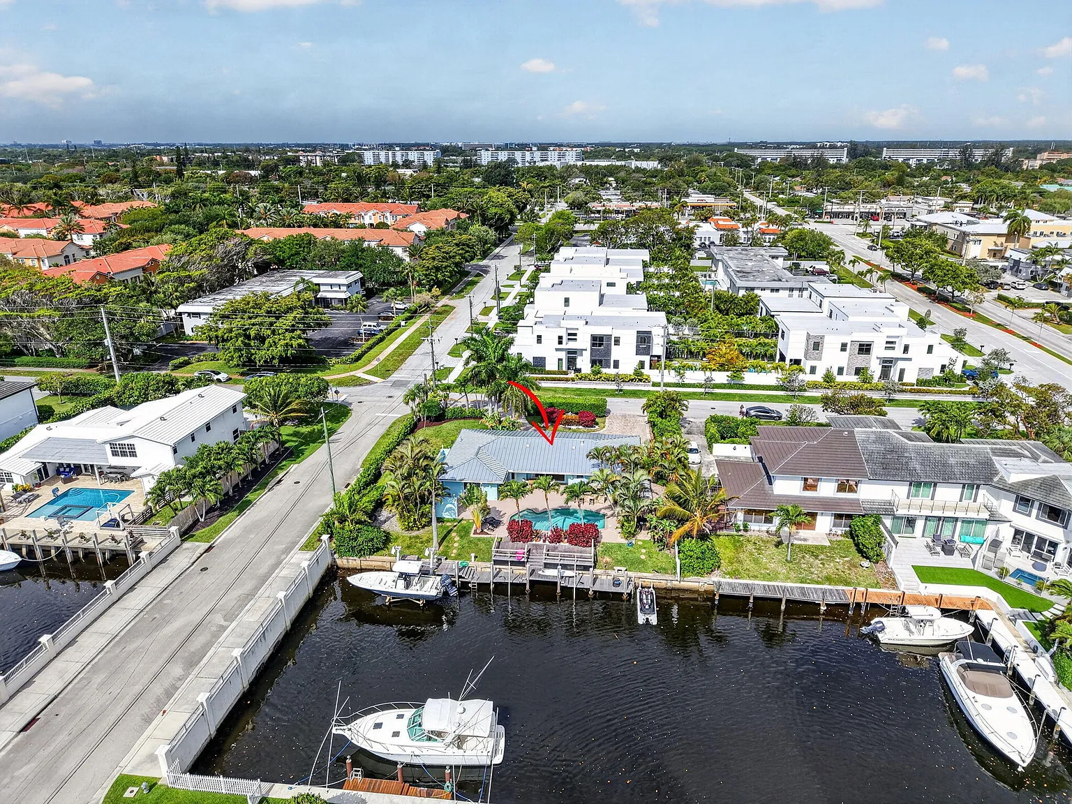 Aerial view of the subject lot from the south, with neighboring new construction visible across the canal